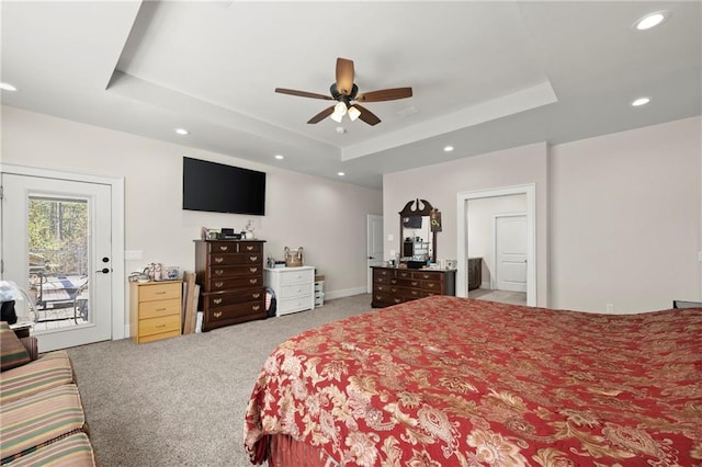 bedroom with a raised ceiling, ceiling fan, and access to exterior