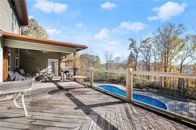 deck with area for grilling and a fenced in pool