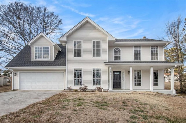 view of front of property with a porch, a garage, and a front lawn