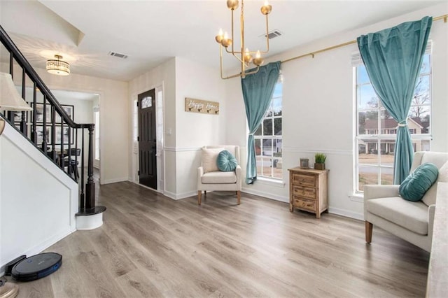 foyer entrance featuring a notable chandelier, hardwood / wood-style flooring, and a healthy amount of sunlight