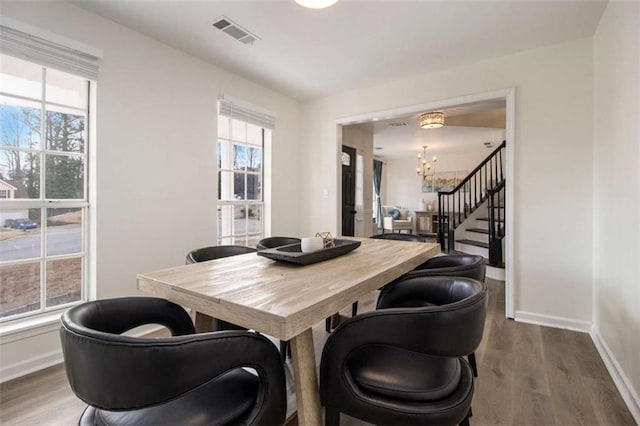 dining space with an inviting chandelier and hardwood / wood-style flooring