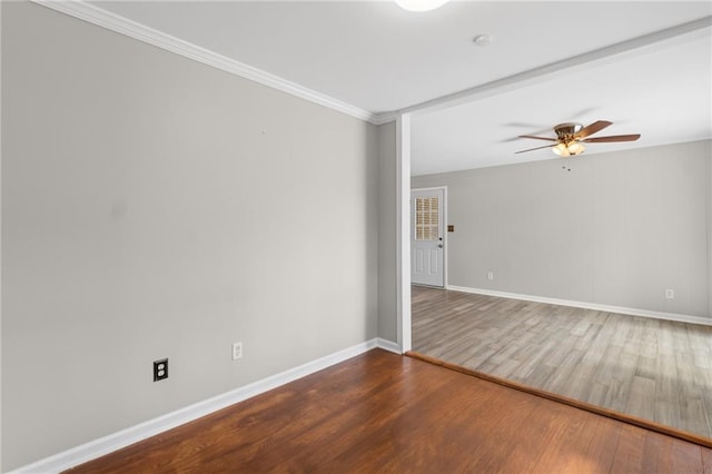 empty room with crown molding, ceiling fan, wood finished floors, and baseboards