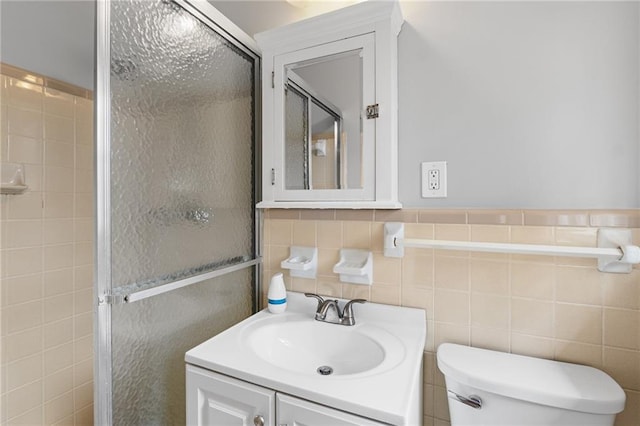 full bathroom featuring toilet, a shower stall, vanity, and tile walls