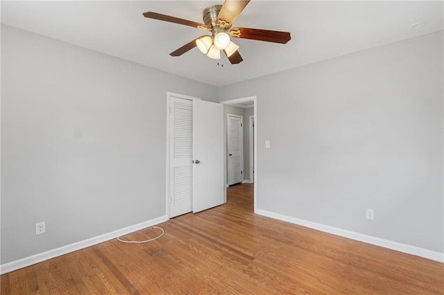 spare room featuring light wood-style floors, ceiling fan, and baseboards