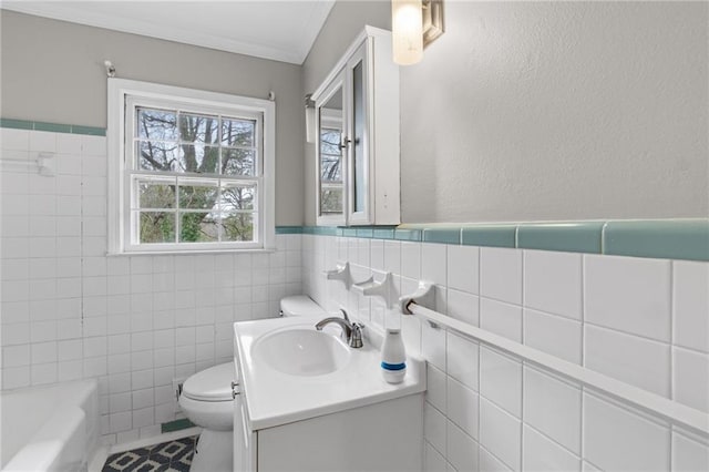 bathroom with a washtub, toilet, vanity, tile walls, and crown molding