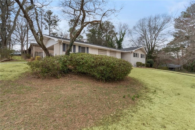 view of home's exterior with brick siding and a lawn