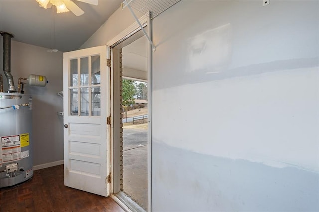 doorway featuring water heater, ceiling fan, baseboards, and wood finished floors