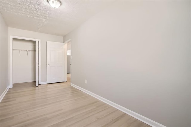 2638 Fieldstone View Ln SE, Conyers, GA 30013 - unfurnished bedroom with light wood-style floors, a closet, and a textured ceiling