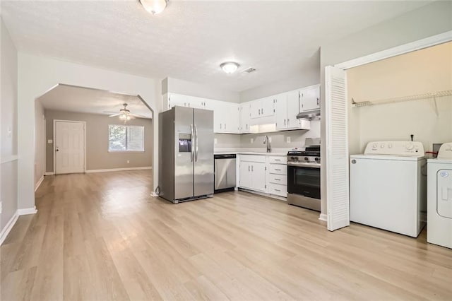 2638 Fieldstone View Ln SE, Conyers, GA 30013 - kitchen featuring stainless steel appliances, washer and dryer, light wood-style floors, under cabinet range hood, and light countertops