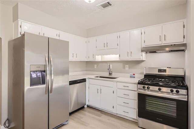 2638 Fieldstone View Ln SE, Conyers, GA 30013 - kitchen featuring stainless steel appliances, under cabinet range hood, light countertops, light wood finished floors, and white cabinets