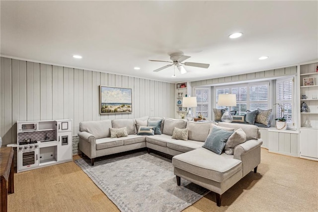 living room featuring built in shelves and ceiling fan