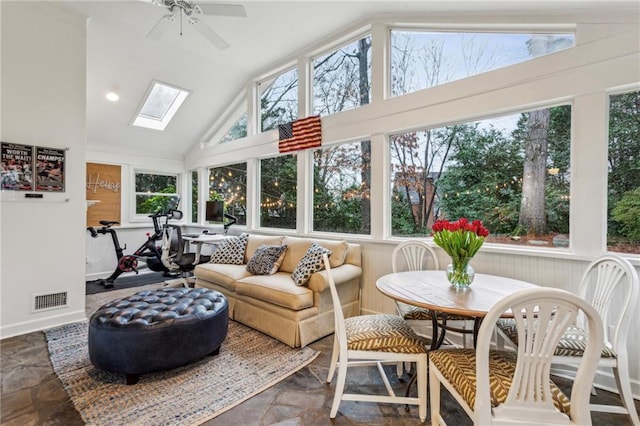 sunroom with ceiling fan, a wealth of natural light, and vaulted ceiling with skylight