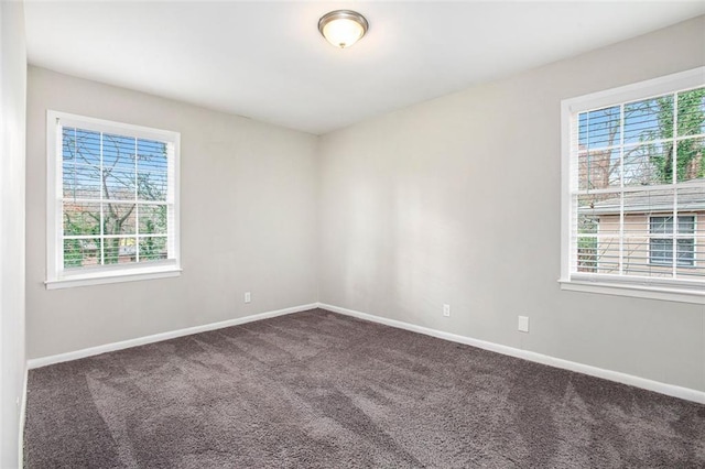 spare room featuring dark colored carpet