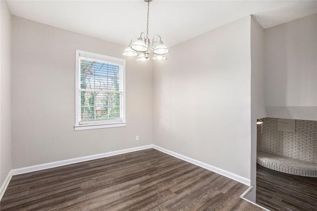 spare room featuring dark hardwood / wood-style floors and a notable chandelier