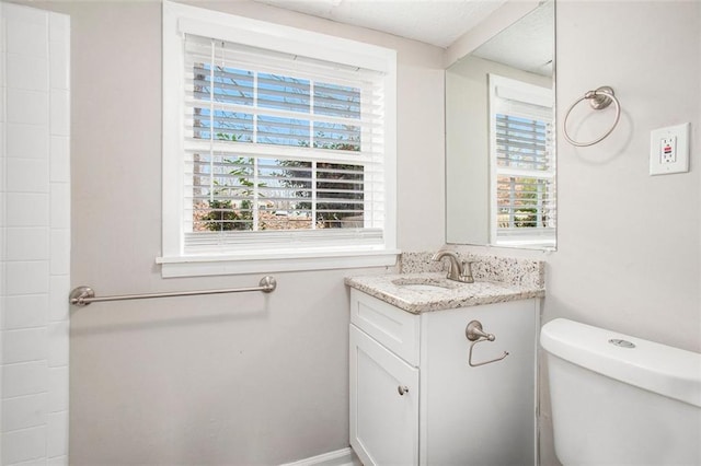 bathroom featuring vanity, toilet, and plenty of natural light