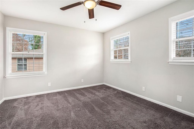 unfurnished room featuring ceiling fan and dark colored carpet