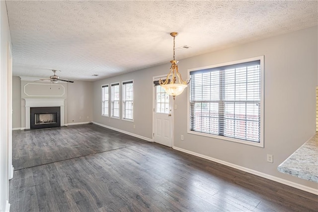 1241 Hogan Ridge Ct, Grayson, GA 30017 - unfurnished living room with a ceiling fan, dark wood-style floors, a textured ceiling, baseboards, and a fireplace with flush hearth