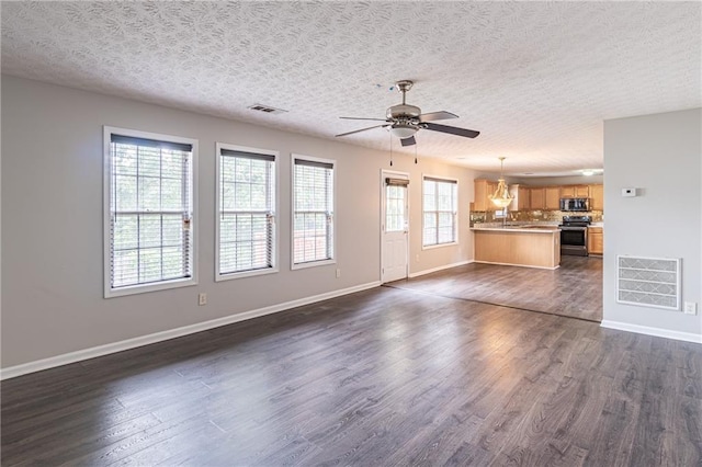 1241 Hogan Ridge Ct, Grayson, GA 30017 - unfurnished living room with a chandelier, ceiling fan, dark wood finished floors, baseboards, and a textured ceiling