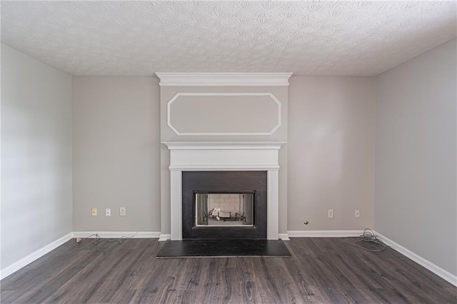1241 Hogan Ridge Ct, Grayson, GA 30017 - unfurnished living room featuring wood finished floors, a textured ceiling, a fireplace with raised hearth, and baseboards