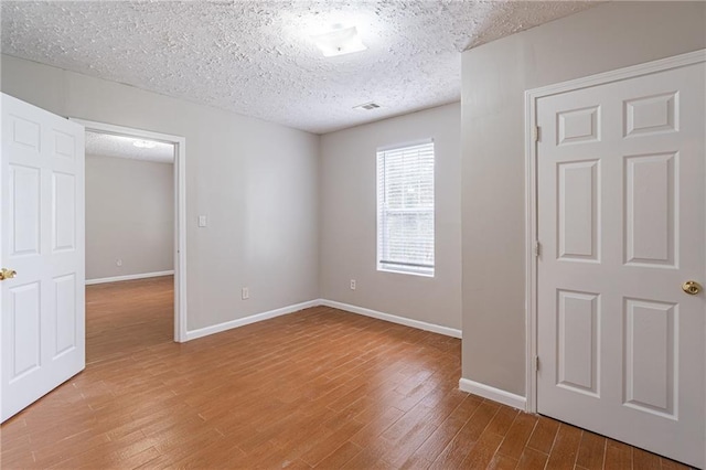1241 Hogan Ridge Ct, Grayson, GA 30017 - empty room featuring a textured ceiling, wood finished floors, and baseboards