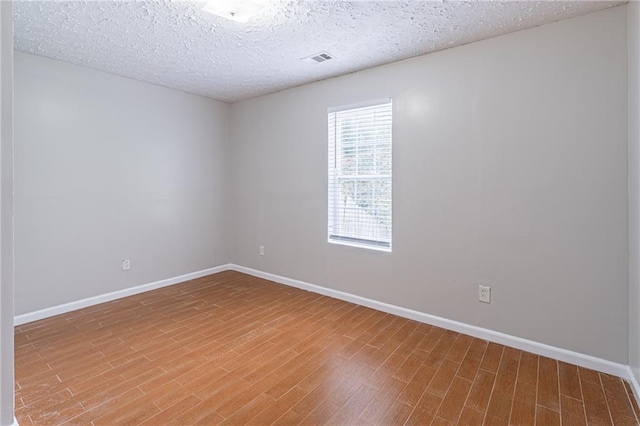 1241 Hogan Ridge Ct, Grayson, GA 30017 - spare room featuring wood finished floors, baseboards, and a textured ceiling
