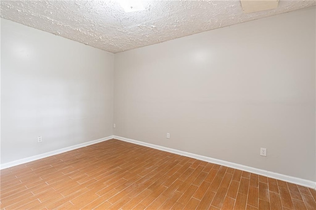1241 Hogan Ridge Ct, Grayson, GA 30017 - unfurnished room featuring baseboards, wood finished floors, and a textured ceiling