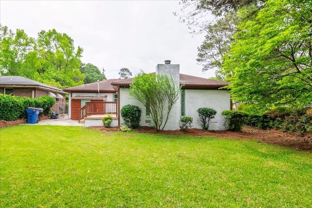 back of house featuring a wooden deck and a yard