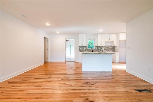 kitchen featuring white cabinetry, tasteful backsplash, and light wood-type flooring