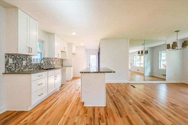 kitchen featuring white cabinetry, sink, and tasteful backsplash