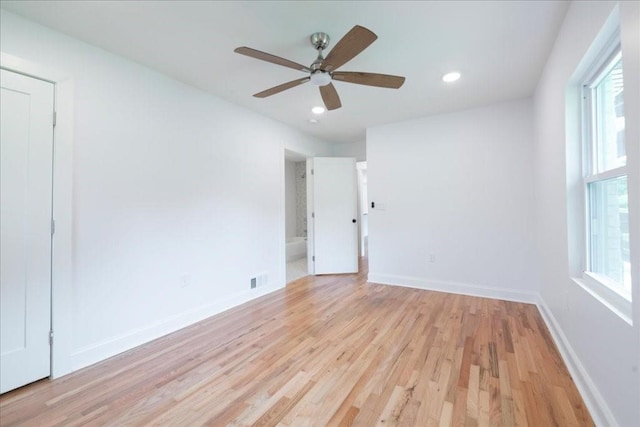 unfurnished room with ceiling fan, a healthy amount of sunlight, and light wood-type flooring