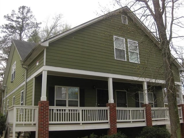 view of side of home featuring covered porch