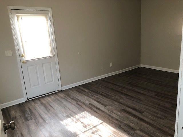 spare room featuring dark wood-type flooring