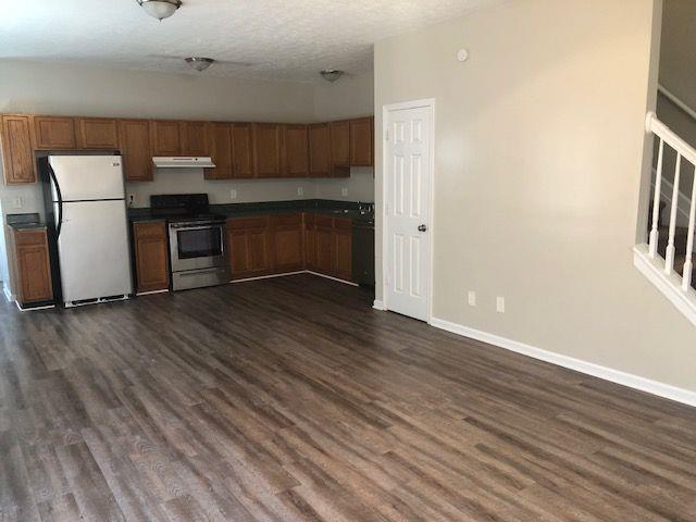 kitchen with fridge, a textured ceiling, electric range, and dark wood-type flooring