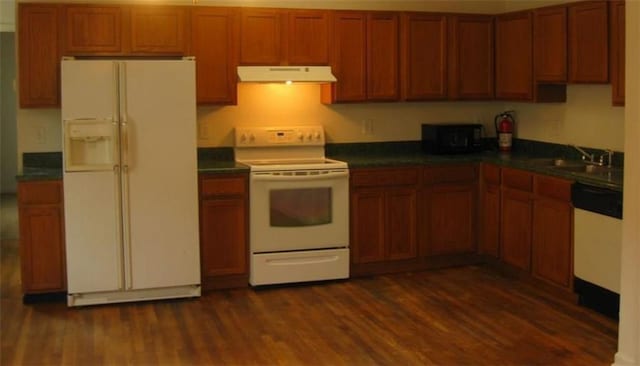 kitchen featuring white appliances, sink, and dark hardwood / wood-style floors