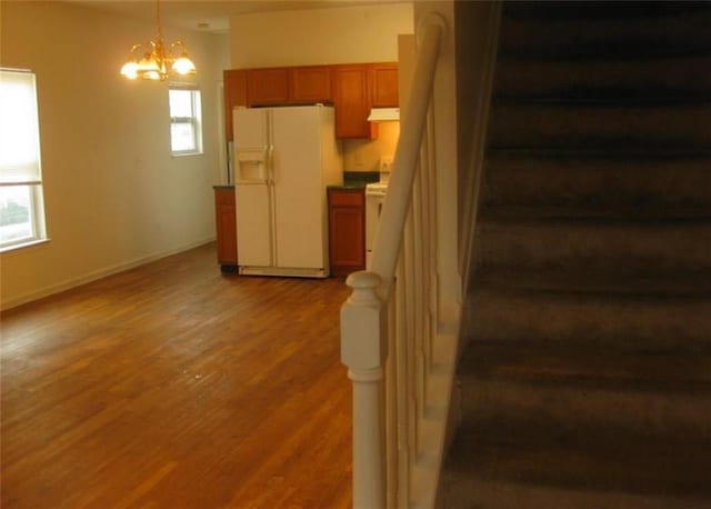 stairs featuring hardwood / wood-style flooring and a chandelier