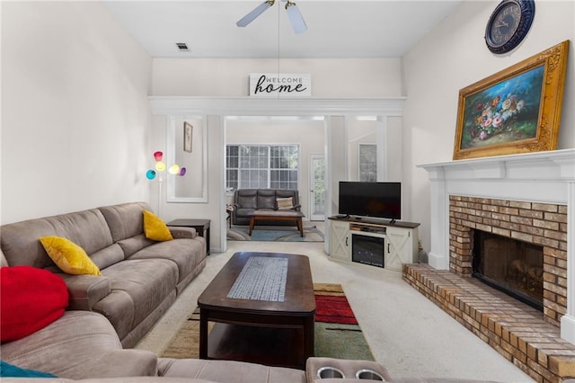 living room with light carpet, ceiling fan, and a brick fireplace