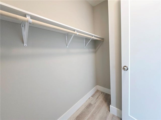 spacious closet with light hardwood / wood-style flooring