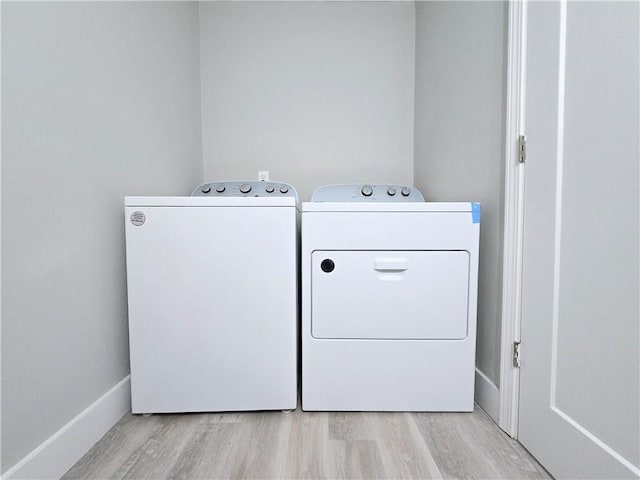 laundry room featuring separate washer and dryer and light hardwood / wood-style floors