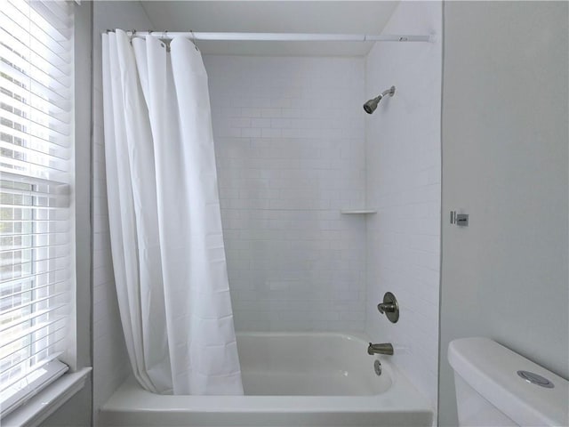 bathroom featuring toilet and shower / bathtub combination with curtain