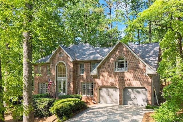 view of front of property featuring brick siding, an attached garage, and driveway