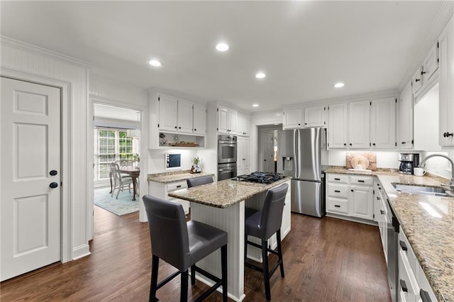 kitchen featuring a sink, white cabinets, light stone countertops, and stainless steel appliances