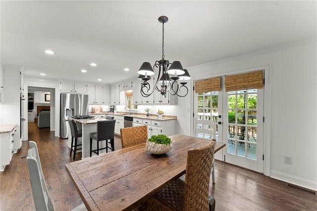 dining space with recessed lighting, ornamental molding, dark wood finished floors, and a chandelier