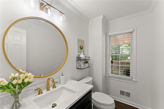 half bathroom featuring a textured ceiling, visible vents, crown molding, vanity, and toilet