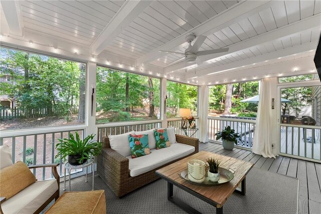 sunroom featuring ceiling fan, beam ceiling, and outdoor lounge area