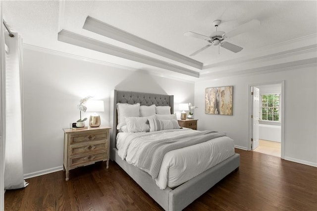 bedroom with baseboards, a tray ceiling, ornamental molding, and wood finished floors