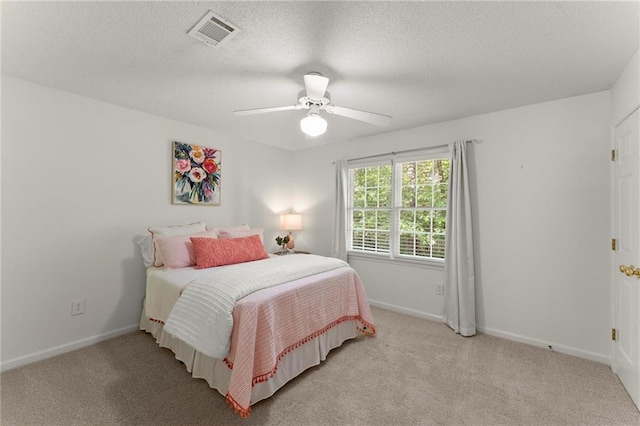bedroom featuring light colored carpet, baseboards, visible vents, and a ceiling fan