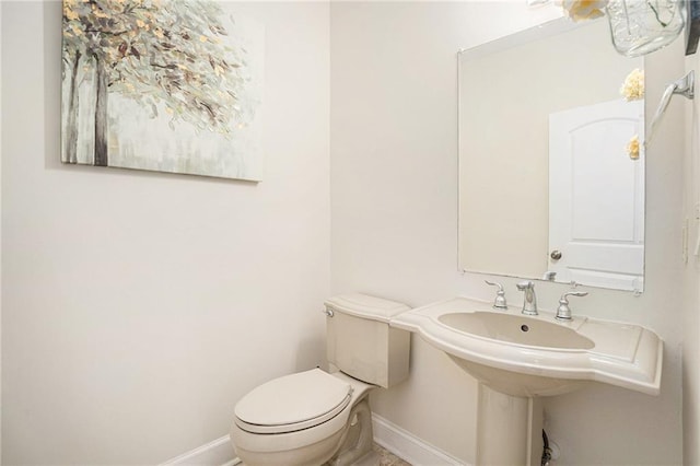 bathroom featuring toilet and baseboards