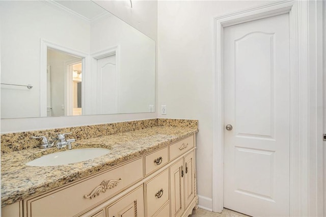 bathroom with crown molding, vanity, and baseboards