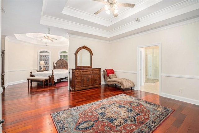 bedroom featuring wood-type flooring, baseboards, ornamental molding, and a raised ceiling