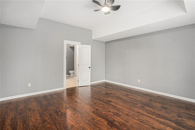 empty room with baseboards, wood finished floors, and ceiling fan